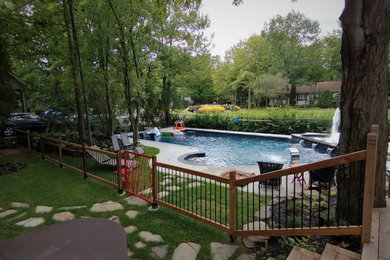 Photo of a large contemporary partial sun backyard stone and metal fence water fountain landscape in Other for summer.