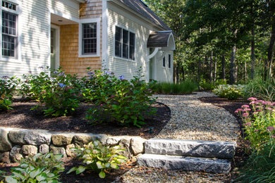 Photo of a mid-sized transitional partial sun front yard gravel retaining wall landscape in Boston.