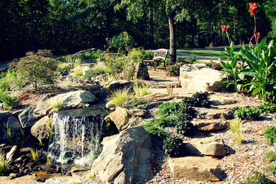 This is an example of a traditional full sun front yard stone water fountain landscape in Atlanta.