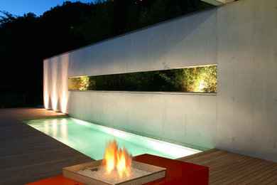 Photo of a modern backyard concrete paver landscaping in Toronto with a fire pit.
