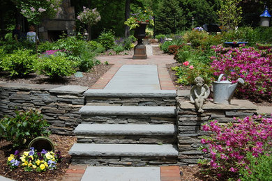 Ejemplo de jardín de tamaño medio en patio trasero con jardín francés y adoquines de piedra natural
