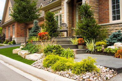 Photo of a mid-sized contemporary full sun front yard stone landscaping in Toronto for summer.