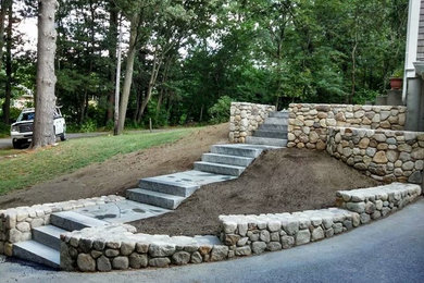 Design ideas for a large partial sun front yard concrete paver retaining wall landscape in Boston.