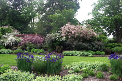 This is an example of a large traditional backyard formal garden in New York.