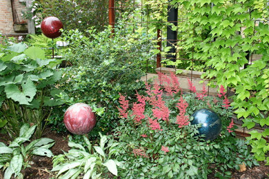 Cette image montre un jardin arrière design avec une exposition partiellement ombragée et un paillis.