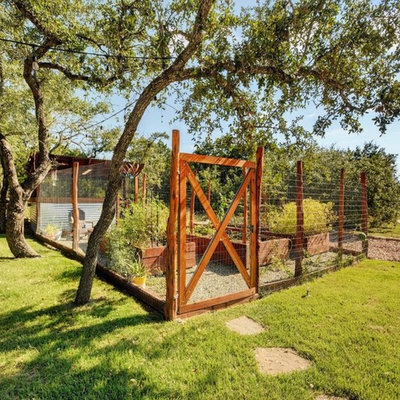 This is an example of a mid-sized rustic full sun side yard gravel landscaping in Austin for spring.