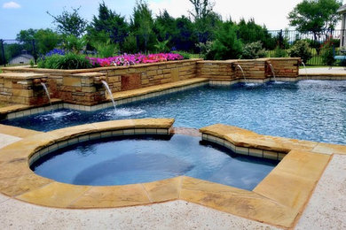 Large mountain style backyard stone pool photo in Dallas