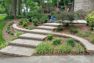 Design ideas for a hillside concrete paver retaining wall landscape in Raleigh.