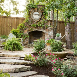 Klassischer Garten mit Natursteinplatten und Kamin in Little Rock