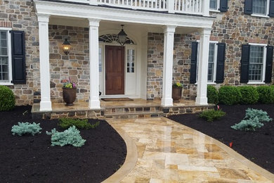 Design ideas for a mid-sized traditional full sun front yard stone landscaping in New York.