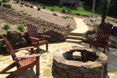 Inspiration for a mid-sized craftsman shade backyard stone landscaping in Other with a fire pit.