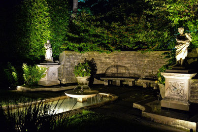 Diseño de jardín clásico grande en patio trasero con jardín francés, exposición parcial al sol y adoquines de piedra natural