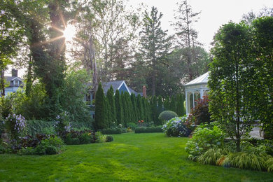 Imagen de jardín tradicional grande en patio trasero con jardín francés y exposición parcial al sol