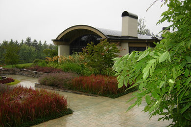Aménagement d'un jardin arrière contemporain avec des pavés en pierre naturelle.
