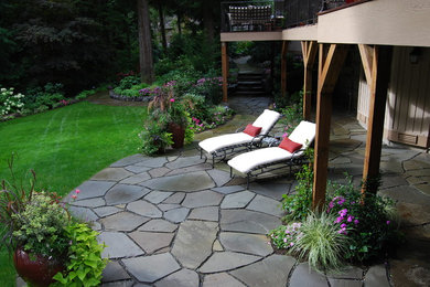 Пример оригинального дизайна: большой летний регулярный сад на заднем дворе в классическом стиле с полуденной тенью и покрытием из каменной брусчатки