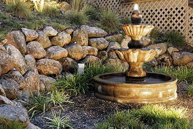 Inspiration for a mid-sized mediterranean drought-tolerant and full sun hillside concrete paver and wood fence water fountain landscape in San Francisco.
