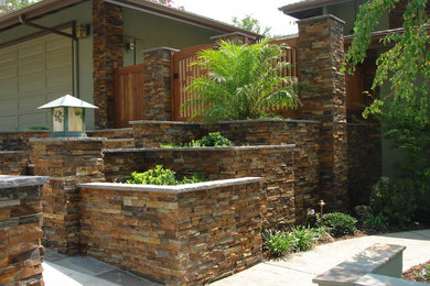 Design ideas for a large asian full sun front yard concrete paver retaining wall landscape in Los Angeles.