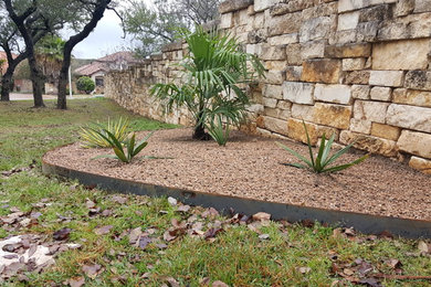 Photo of a mid-sized contemporary full sun backyard gravel landscaping in Austin.