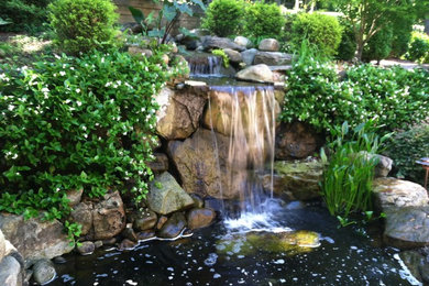 Photo of a mid-sized traditional partial sun hillside stone water fountain landscape in Charleston for summer.
