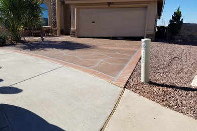 This is an example of a mid-sized rustic front yard concrete paver driveway in Other.