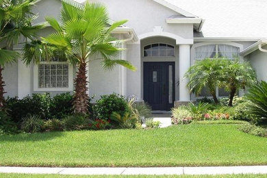 This is an example of a mid-sized partial sun front yard concrete paver formal garden in Tampa.