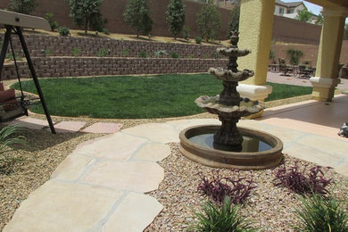 Foto de jardín tradicional renovado de tamaño medio en patio trasero con jardín francés, fuente, exposición total al sol y adoquines de piedra natural
