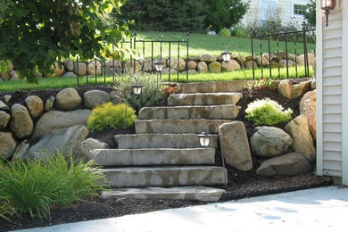 Photo of a mid-sized full sun front yard brick retaining wall landscape in Grand Rapids.