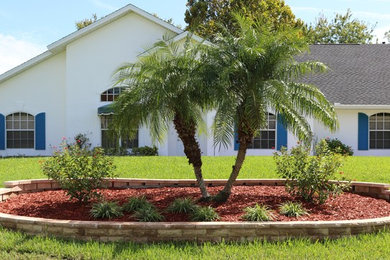 Photo of a small traditional full sun front yard concrete paver retaining wall landscape in Orlando.