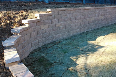 Photo of a huge rustic backyard retaining wall landscape in Raleigh.