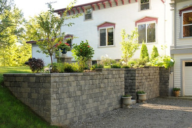 Foto de jardín grande en patio lateral con muro de contención, exposición parcial al sol y gravilla