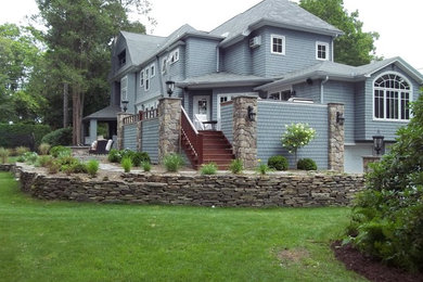 Design ideas for a large full sun front yard stone retaining wall landscape in New York.