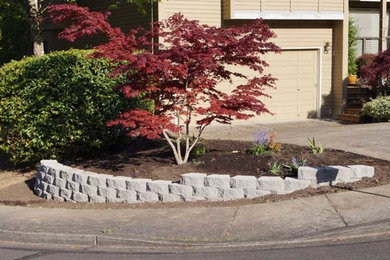 This is an example of a mid-sized traditional full sun front yard brick retaining wall landscape in Portland.