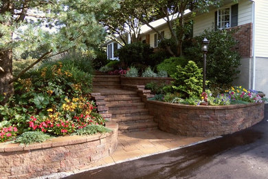 This is an example of a large rustic front partial sun garden in New York with a retaining wall and brick paving.