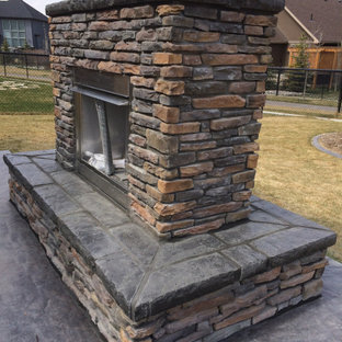 Mittelgroßer Garten hinter dem Haus mit Kamin und Betonplatten in Calgary