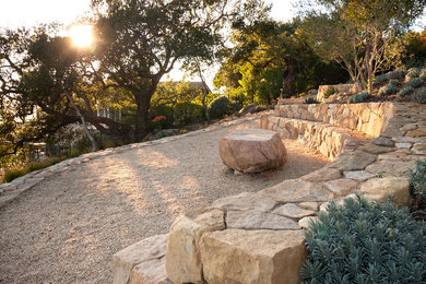 Diseño de jardín mediterráneo en patio delantero con adoquines de piedra natural
