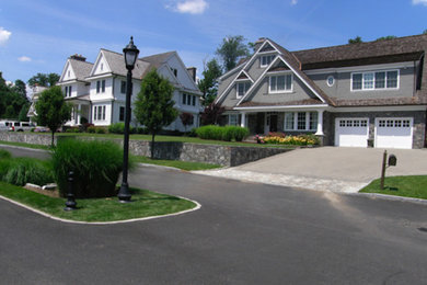 This is an example of a large traditional front yard stone landscaping in New York.