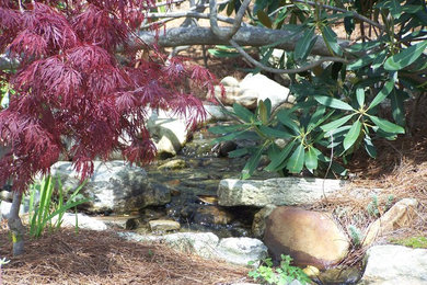 Halbschattiger Klassischer Garten im Sommer mit Wasserspiel und Natursteinplatten in Sonstige