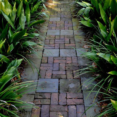 This is an example of a mid-sized tropical front yard brick garden path in Atlanta.