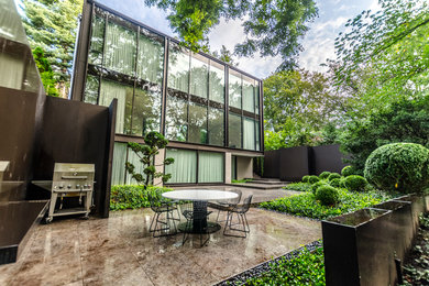 Ispirazione per un giardino formale moderno esposto a mezz'ombra di medie dimensioni e dietro casa in estate con pavimentazioni in pietra naturale