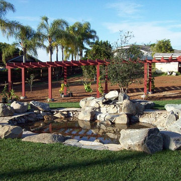 Rural backyard featuring water feature and grape arbor