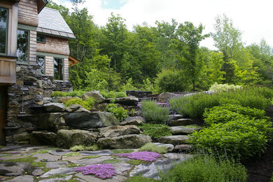 Réalisation d'un jardin arrière chalet de taille moyenne avec des pavés en pierre naturelle.