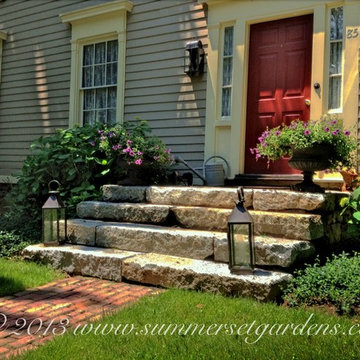 Rustic granite steps and a reclaimed brick walkway