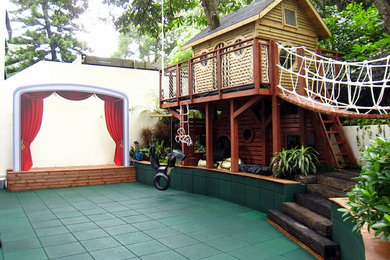 Idee per un grande giardino formale tropicale in ombra dietro casa in primavera con uno spazio giochi e pacciame