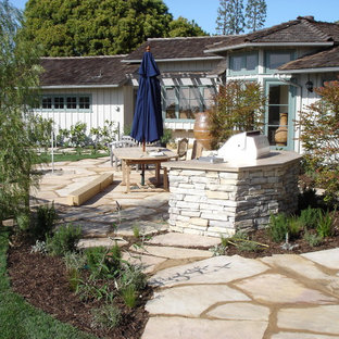 Design ideas for a mid-sized traditional full sun backyard stone landscaping in Los Angeles.