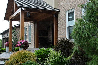 Inspiration for a mid-sized craftsman full sun front yard stone landscaping in Toronto.