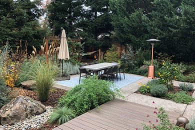 Réalisation d'un xéropaysage arrière chalet de taille moyenne et l'automne avec un point d'eau, une exposition partiellement ombragée et une terrasse en bois.