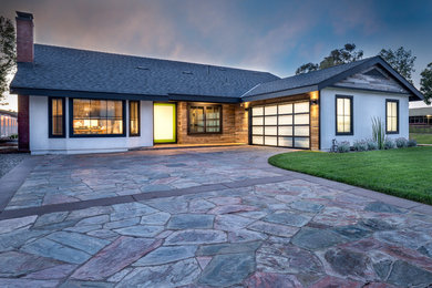 Imagen de acceso privado actual de tamaño medio en patio delantero con exposición total al sol, adoquines de piedra natural y brasero