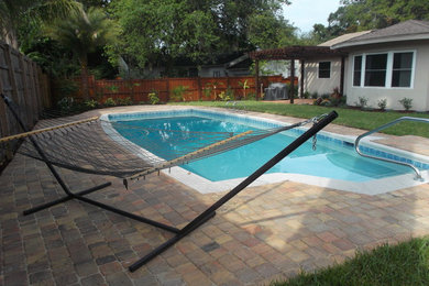 Modelo de piscina en patio trasero con adoquines de hormigón