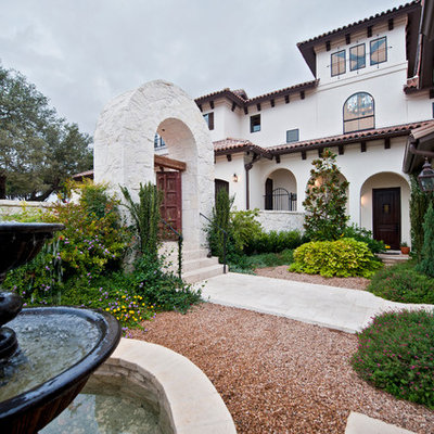 This is an example of a large mediterranean full sun backyard stone landscaping in Austin.