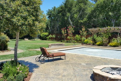 Ejemplo de jardín contemporáneo grande en patio trasero con brasero, exposición total al sol y adoquines de hormigón